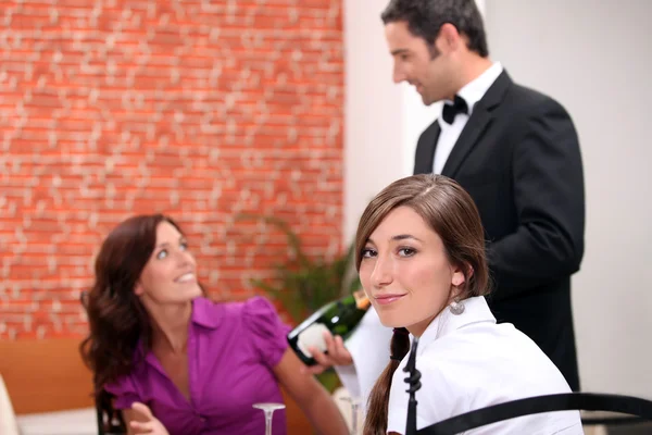 Camarero de vino mostrando una botella de vino espumoso a los clientes — Foto de Stock