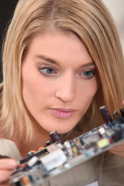 Technicienne regardant un circuit électronique — Photo