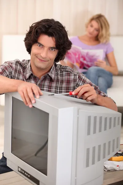 Homem consertando uma velha televisão — Fotografia de Stock