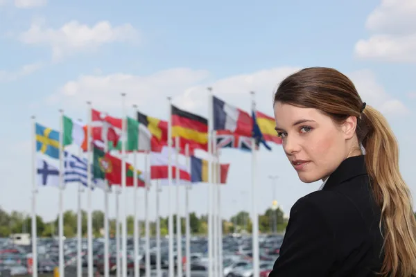 Affärskvinna bredvid flaggor — Stockfoto