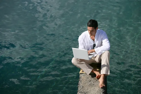 Homme sur un ponton en utilisant un ordinateur — Photo