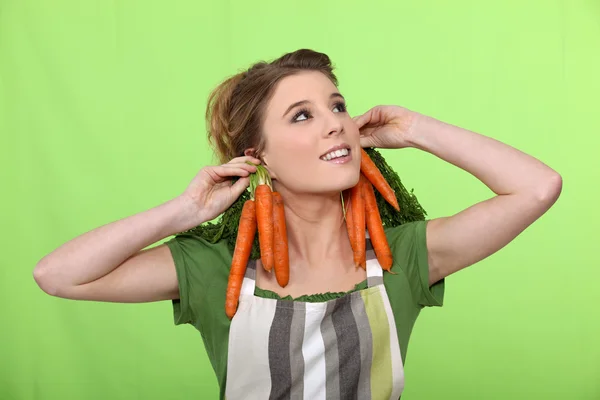 Chica con zanahorias como pendientes —  Fotos de Stock