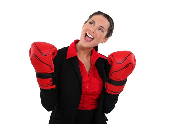 Smiling businesswoman wearing boxing gloves — Stock Photo, Image