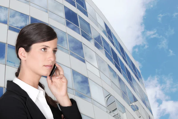 Mujer de negocios inteligente haciendo llamadas al aire libre cerca del edificio — Foto de Stock