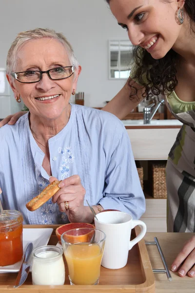 Mulher servindo café da manhã para outra mulher — Fotografia de Stock