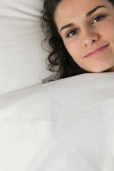 Mladá žena v posteli — Stock fotografie
