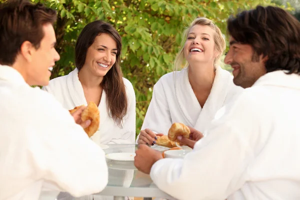 2 つのカップルは庭で朝食を食べながらジョークを共有 — ストック写真