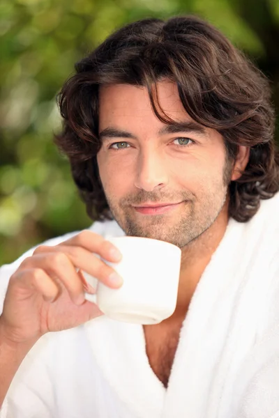 Knappe man drinken van zijn koffie in de tuin — Stockfoto