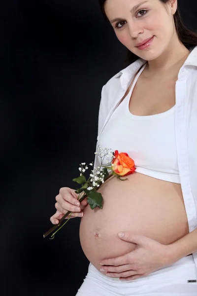 Těhotná žena hospodářství květ — Stock fotografie