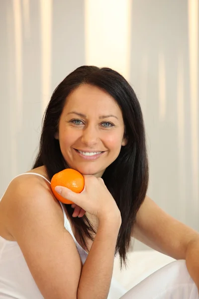 Женщина держит апельсин — стоковое фото