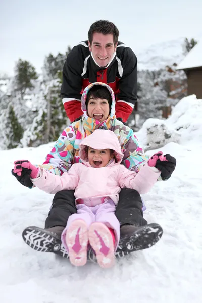 雪橇下坡的家庭 — 图库照片