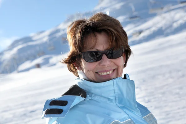 Mujer de mediana edad de pie en la montaña nevada —  Fotos de Stock