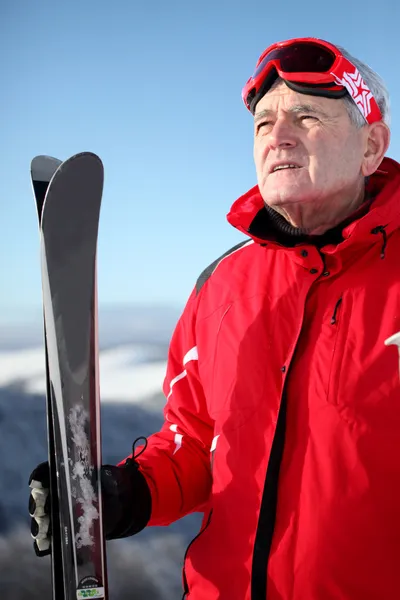 在一座山与滑雪板上的老男人 — 图库照片