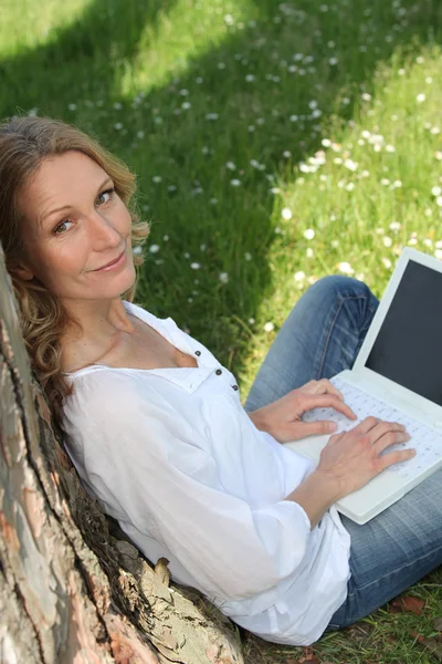 Frau surft im Internet in einem öffentlichen Park — Stockfoto
