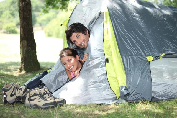 Young couple peeking out of their tent — Stock Photo, Image