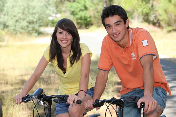 Adolescentes fazendo bicicleta na floresta — Fotografia de Stock