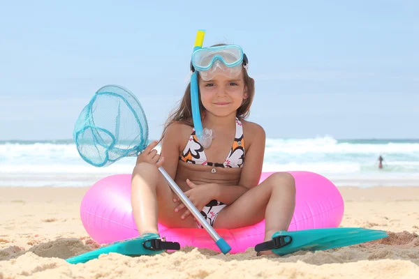 Μικρό κορίτσι στην παραλία με κάθεται σε σημαντήρα με καταδυτικό εξοπλισμό — Φωτογραφία Αρχείου