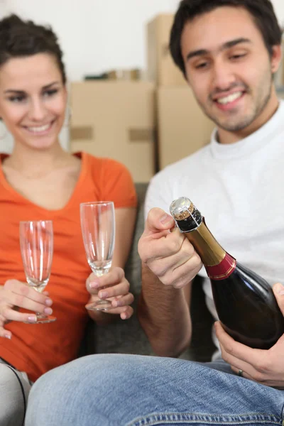Couple opening bottle of champagne — Stock Photo, Image