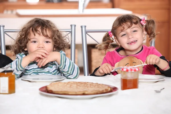 Portrait of two kids at breakfast — Stock Photo, Image