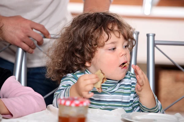 Мальчик ест блинчики — стоковое фото