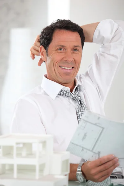 Smiling, relaxed architect looking at plans — Stock Photo, Image