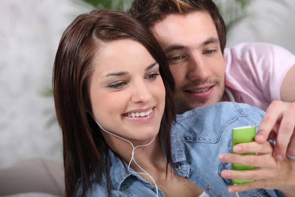 Young couple with a personal music player — Stock Photo, Image