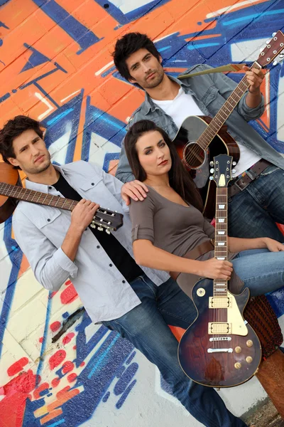 Muzikaal trio tegen graffiti muur — Stockfoto