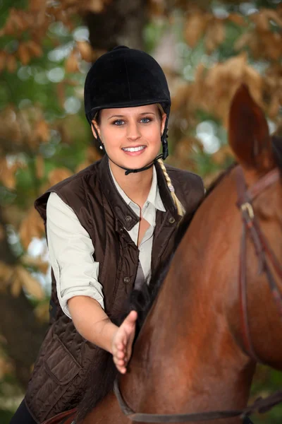 Blonde woman riding a horse — Stockfoto