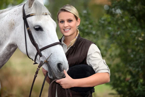 馬の世話をしている若い女性が — ストック写真