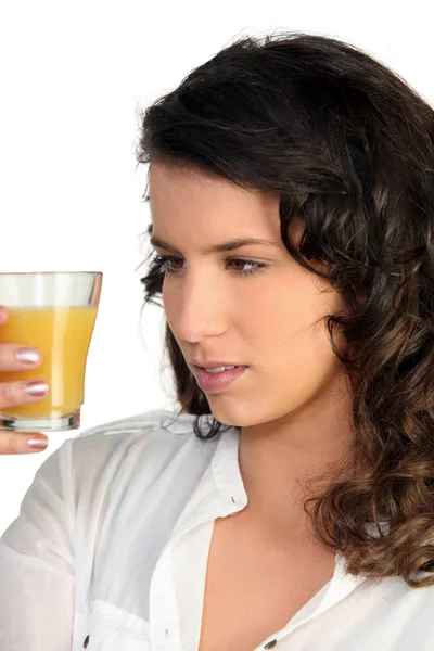 Mulher observando suco de laranja — Fotografia de Stock