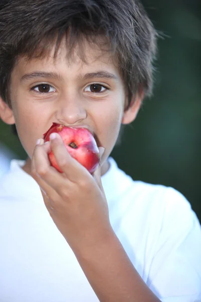Jonge jongen eten een nectarine — Stockfoto