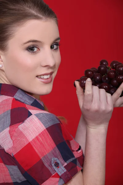 Ung kvinna äter druvor — Stockfoto
