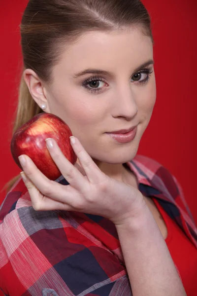Mulher no estúdio comendo maçã vermelha — Fotografia de Stock