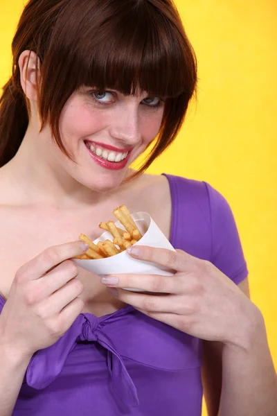 Vrouw een kegel van chips eten — Stockfoto