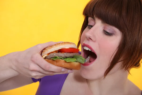 Femme mangeant un hamburger — Photo