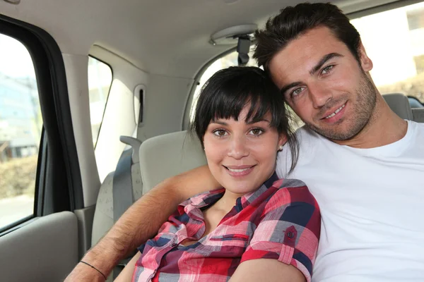 Giovane coppia nel retro di una macchina — Foto Stock