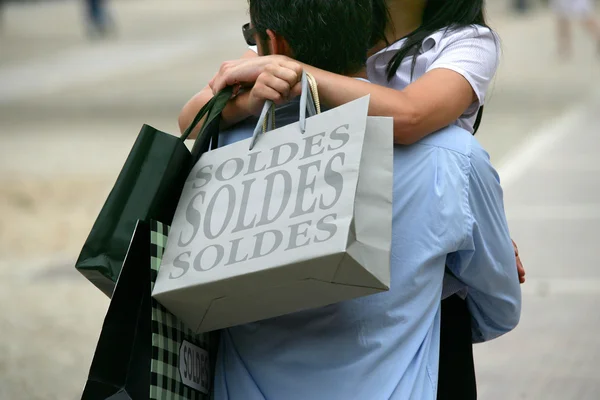 Paar knuffelen met shopping tassen — Stockfoto
