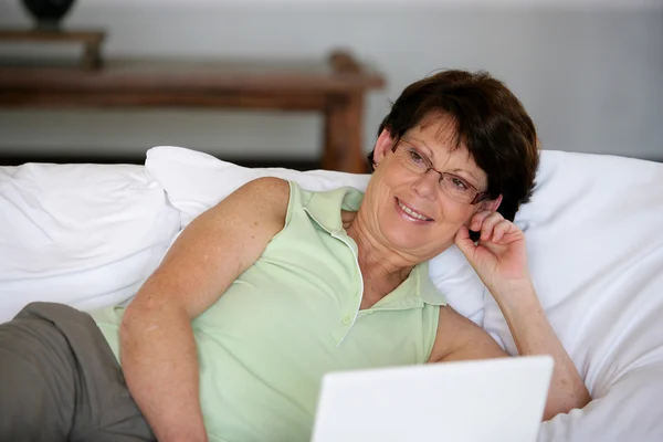 노트북으로 침대에 누워 여자 — 스톡 사진