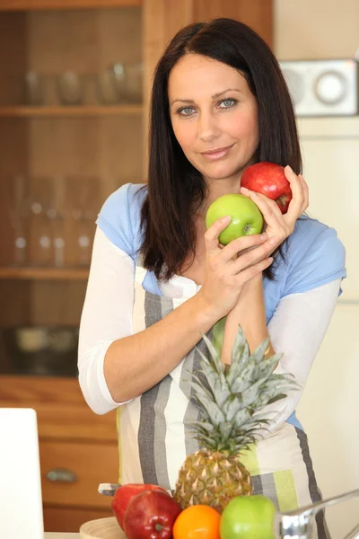 Mujer con fruta en una cocina — Foto de Stock
