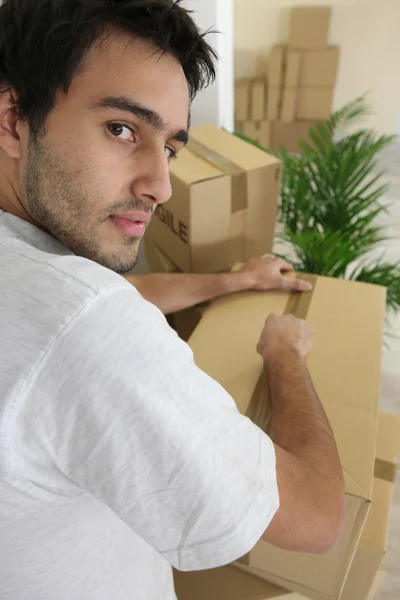 Jovem homem embalagem caixas — Fotografia de Stock