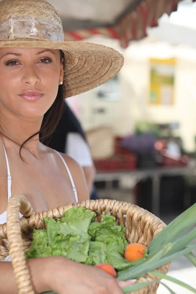 Mulher de verão em um chapéu de palha segurando uma cesta de produtos de mercado — Fotografia de Stock