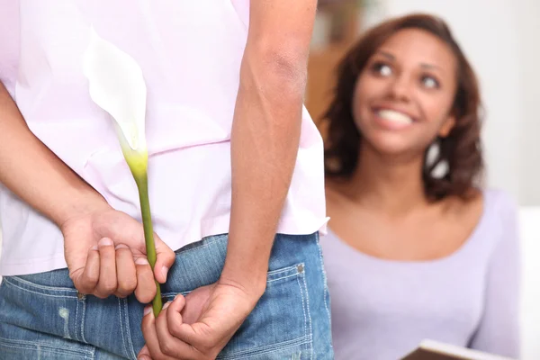 Hombre sorprendiendo a su novia con una flor — Foto de Stock