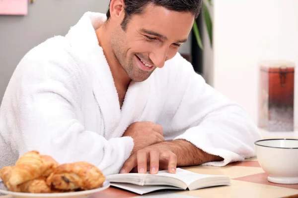 Muž čtení bookat snídaně — Stock fotografie