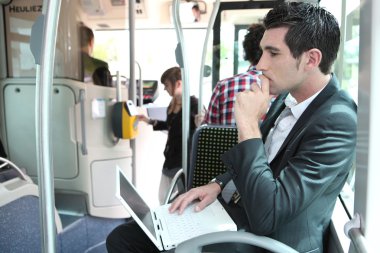 Commuter on a bus with a laptop clipart