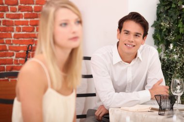 Man admiring blond woman in restaurant clipart