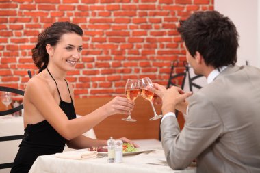 Elegant couple dating in a restaurant clipart