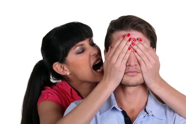 Woman with her hands over a man's eyes clipart