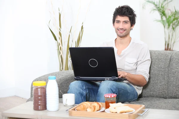 Hombre haciendo la computadora en el desayuno — Foto de Stock