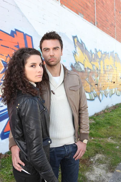 Fashionable young couple stood by wall — Stock Photo, Image