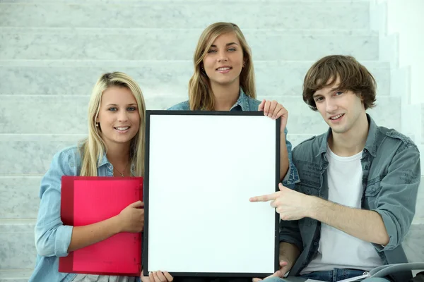Students pointing at white board — Stock Photo, Image